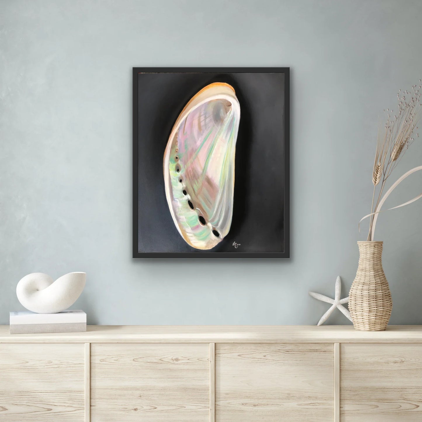 Framed realistic abalone shell painting on wall above modern minimalist console decor
