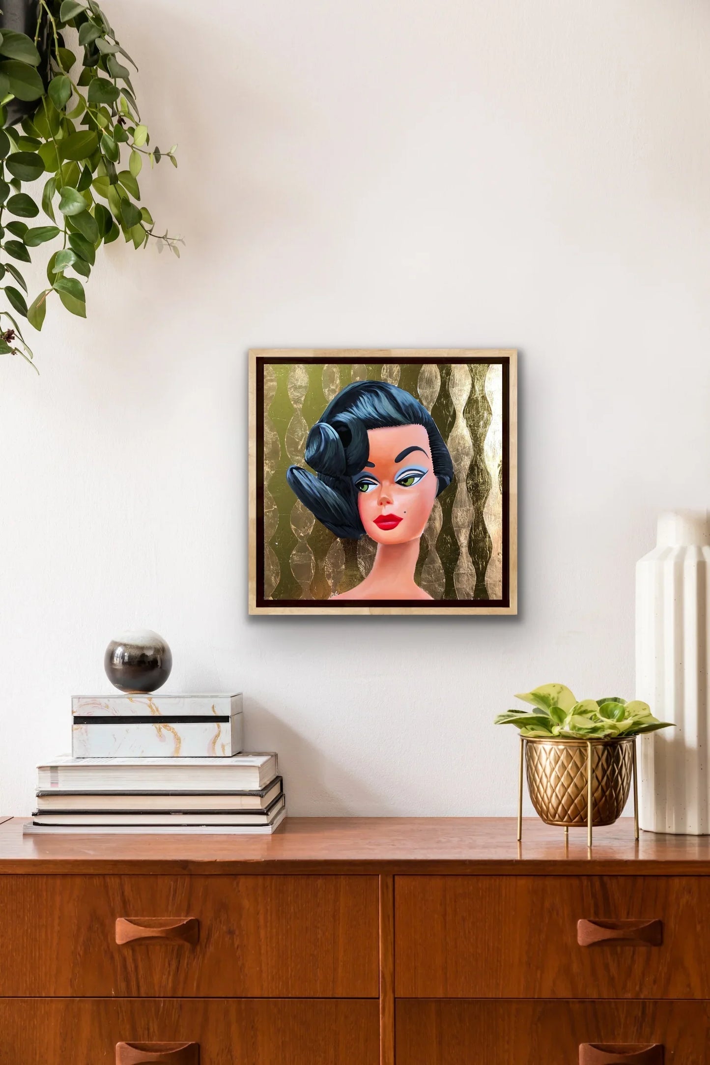 Framed pop art painting of a brunette retro doll against a gold patterned wall, modern decor