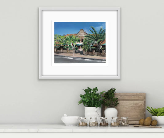 Framed pop art print of Hotel Brunswick with palm trees, displayed above a modern kitchen counter