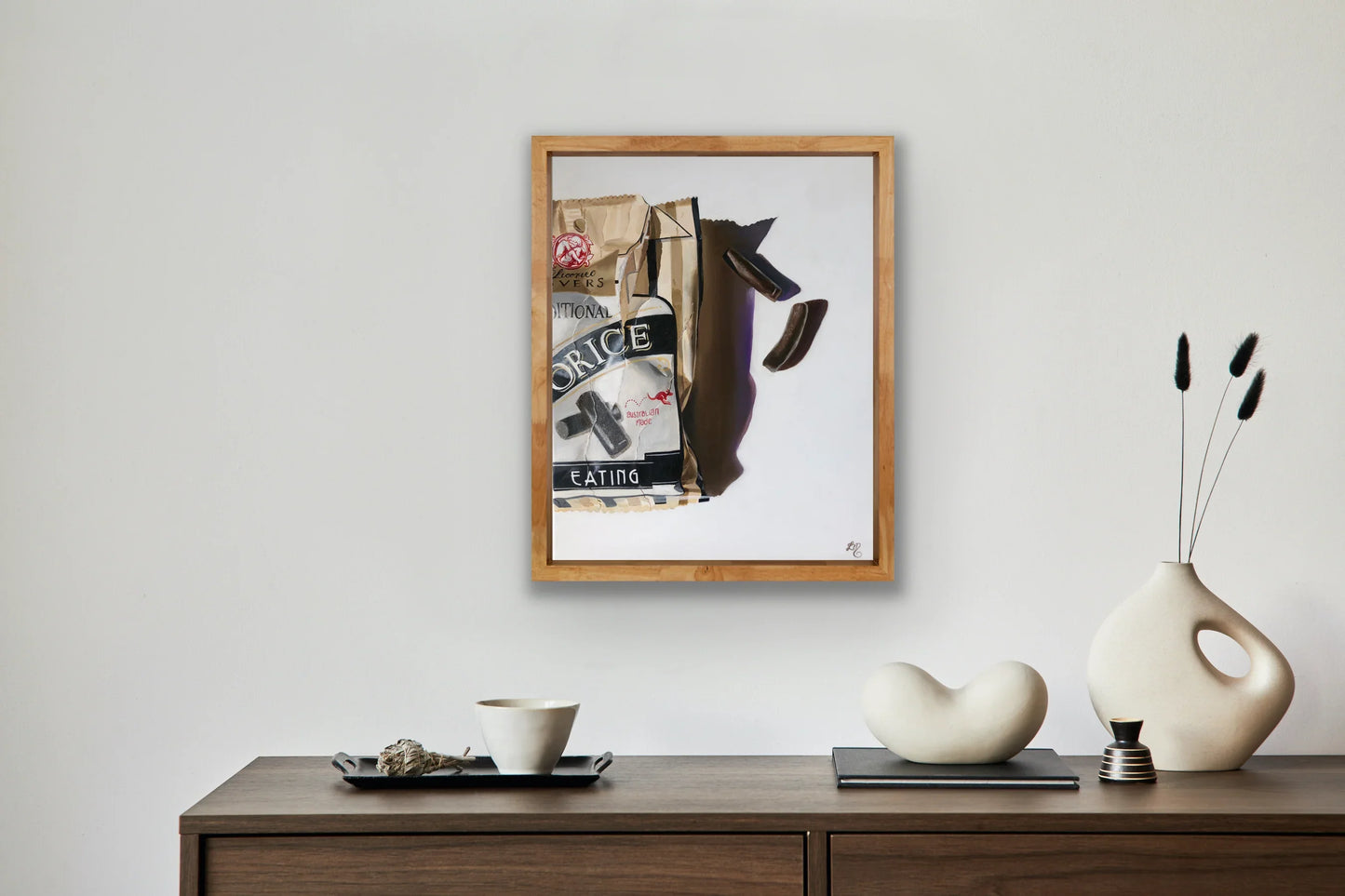 Framed realistic painting of a licorice lolly bag and candies on a minimalist wall
