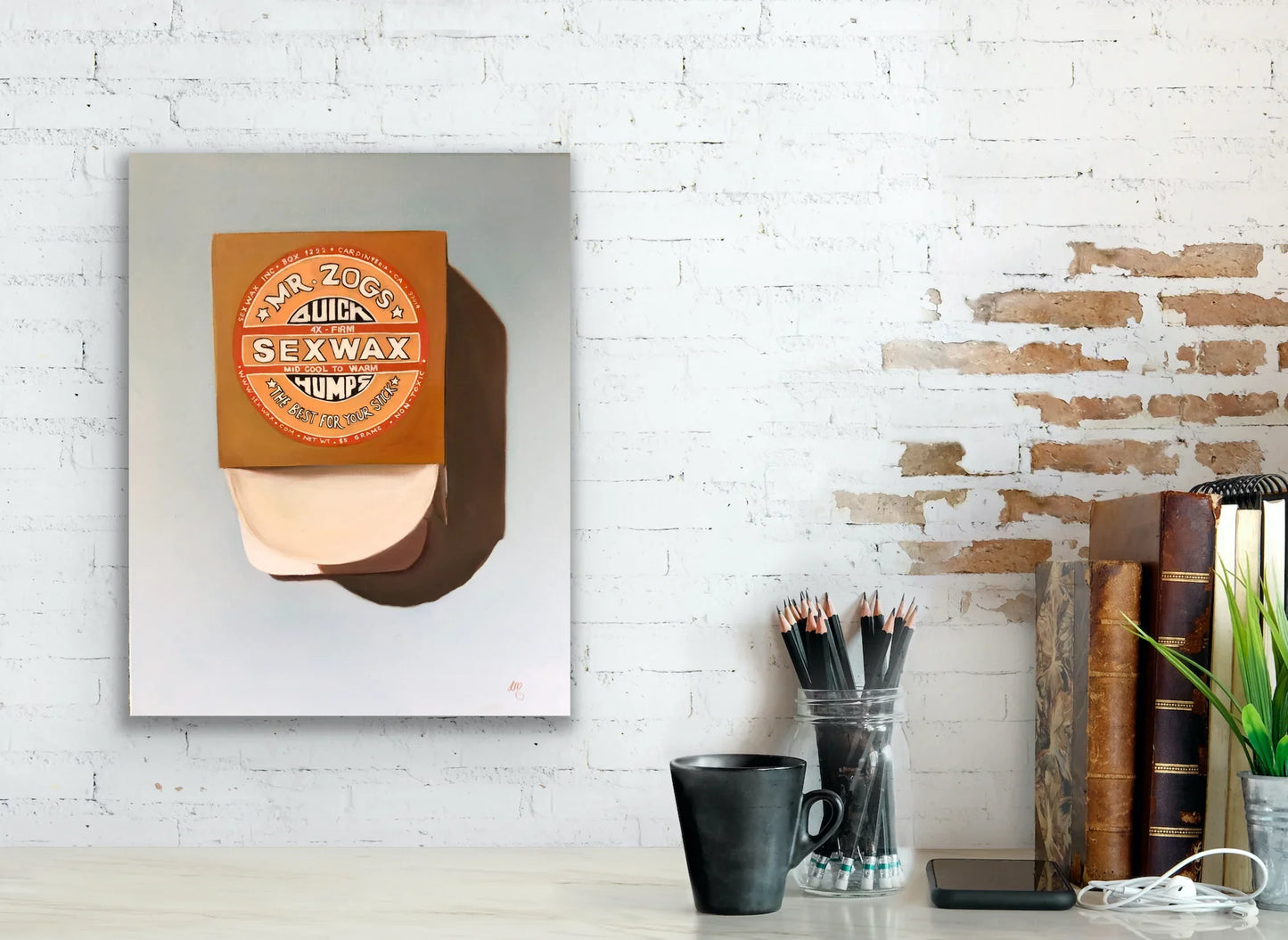 Pop art painting of Mr. Zog's Sex Wax box displayed on a white brick wall above a desk.