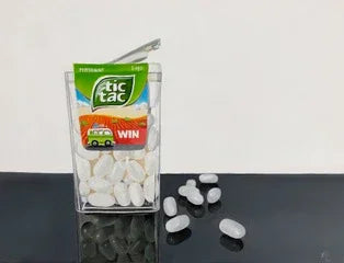 Realistic pop art painting of white Tic Tac mint container with candies on reflective surface
